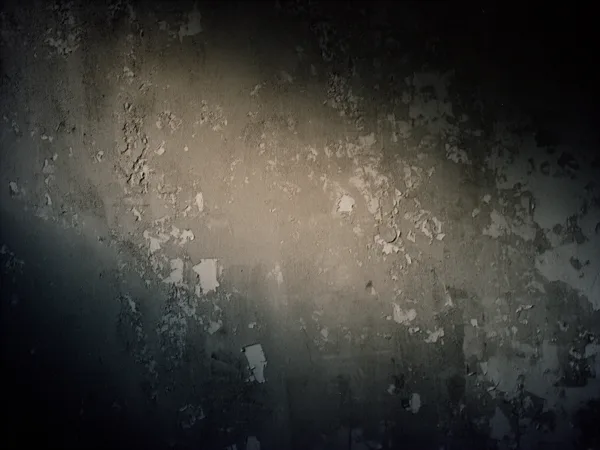 A textured grunge wall with peeling paint and soft lighting highlighting its rough surface.
