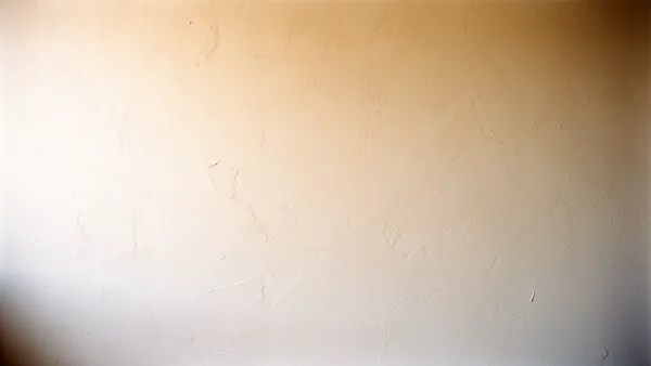 A textured beige plaster wall with intricate patterns and soft natural lighting.
