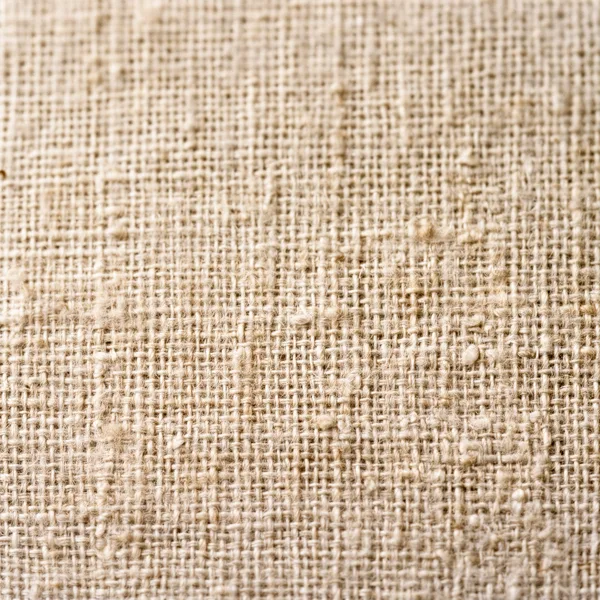 Close-up view of burlap fabric texture with interwoven natural fibers and earthy tones under soft natural light.